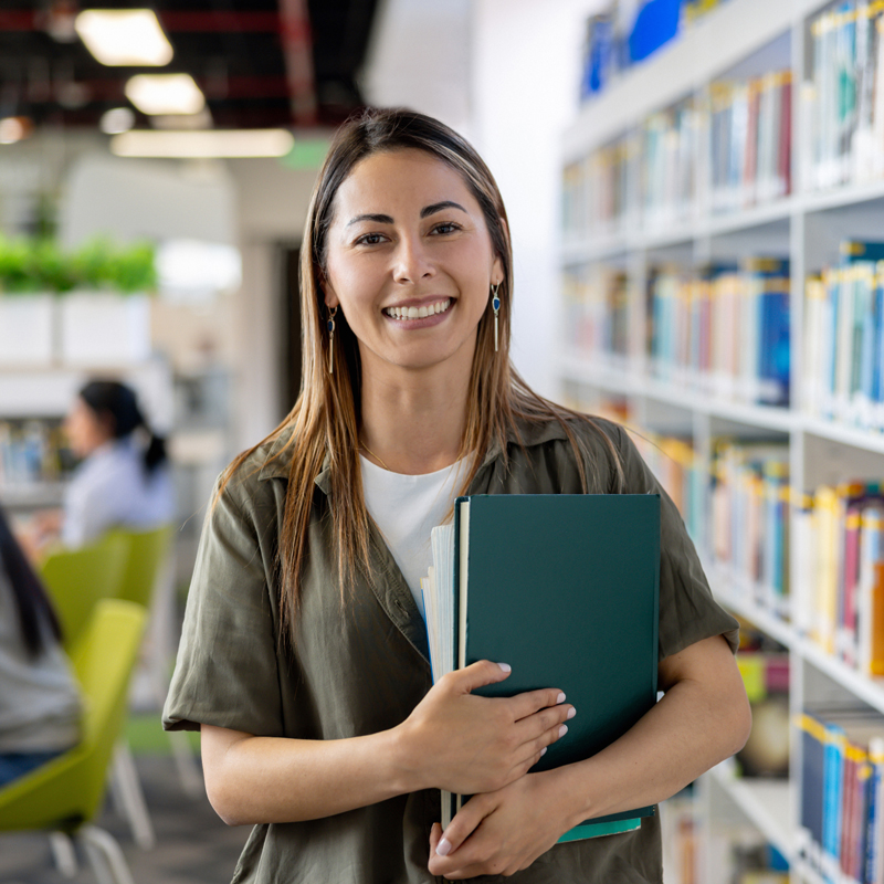student holding a book smiling